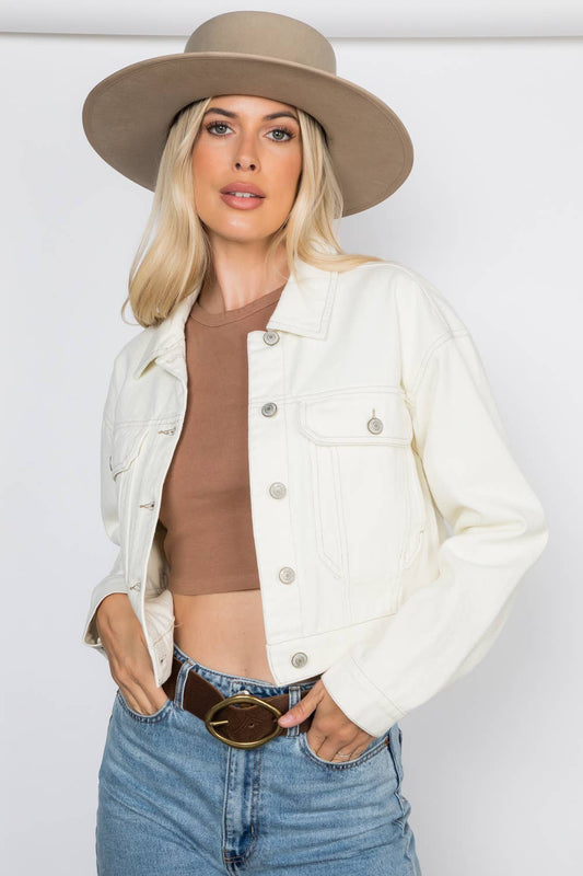 Cropped Ecru Denim Jacket Outerwear by 26 International front left on model with hands in jean pockets wearing hat and belt