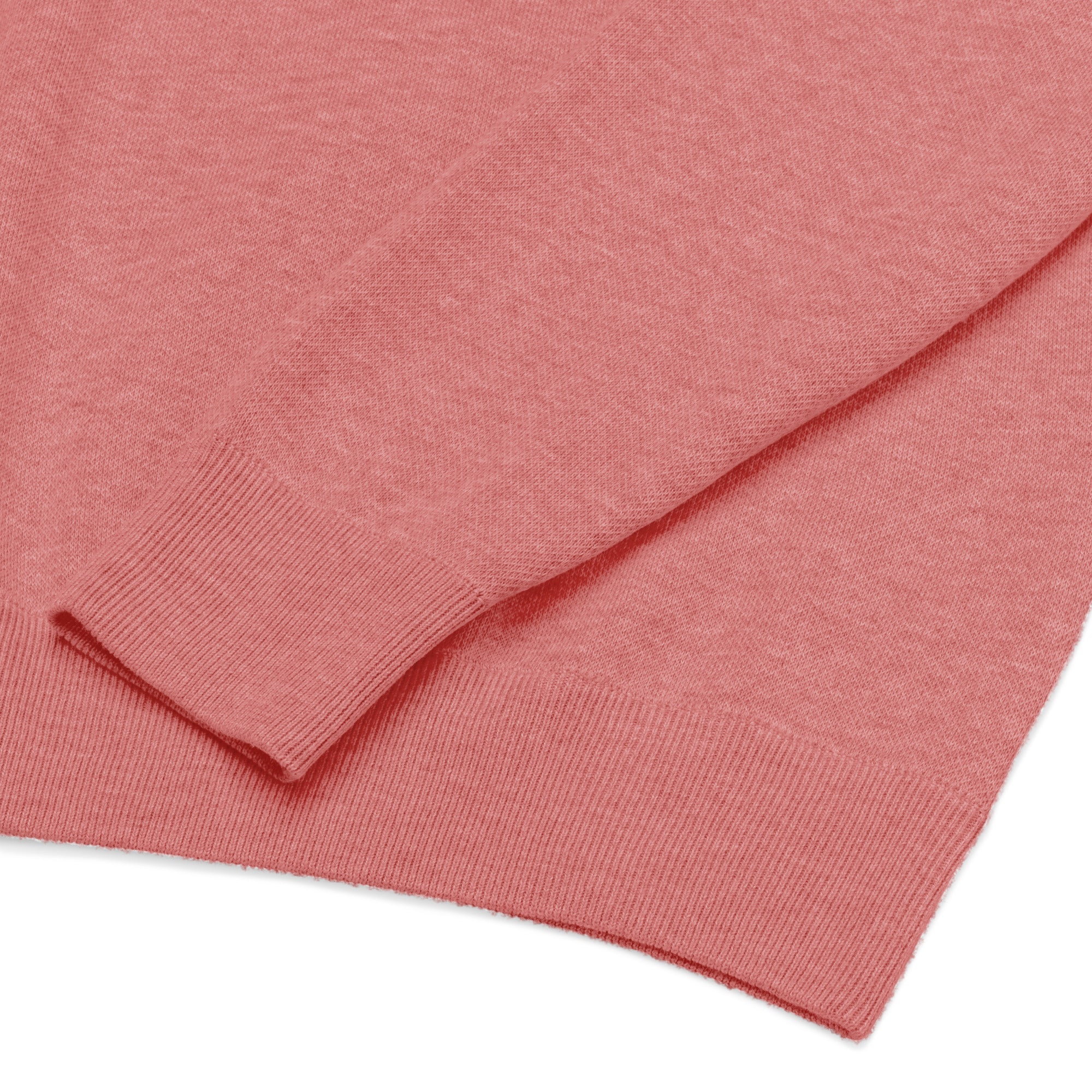 Flattened Close up of material details on lower corner and bottom of one sleeve of pink knitted sweater