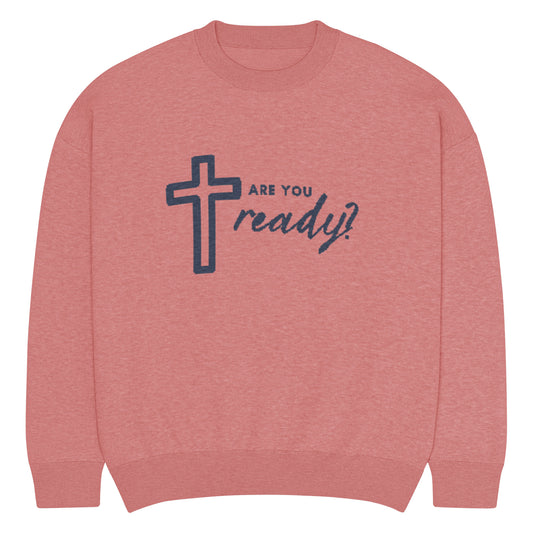 Front flat view of pink knitted sweater with image of cross and text in navy blue