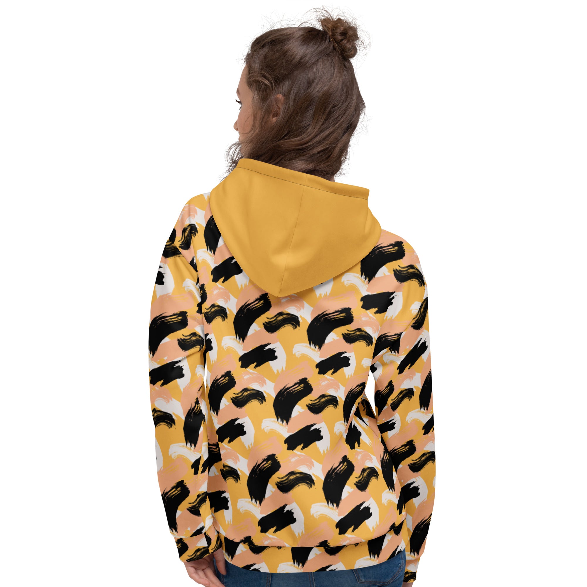 Back of woman wearing a yellow hoodie with black abstract pattern 