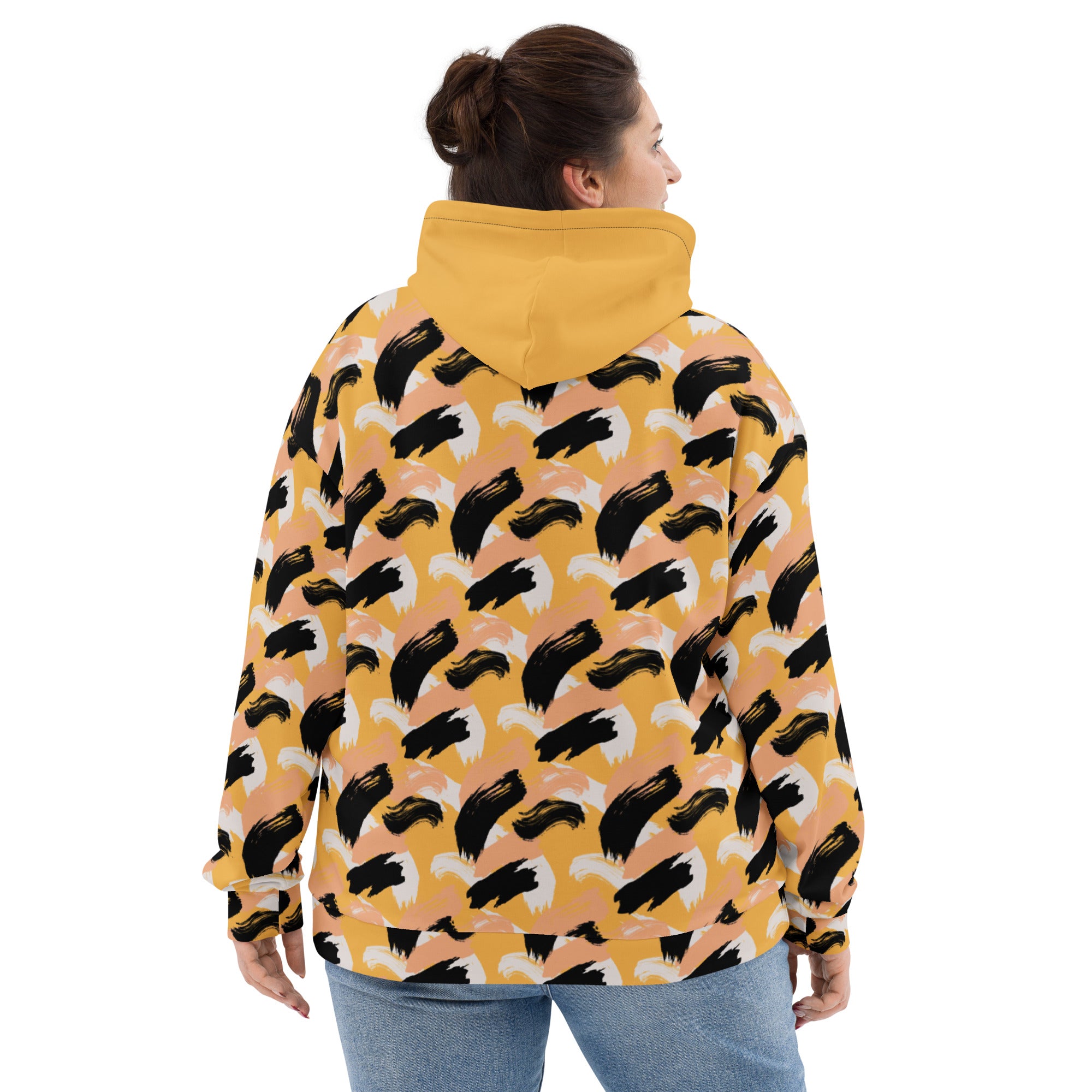 Back of woman wearing a yellow hoodie with an abstract pattern with yellow hood