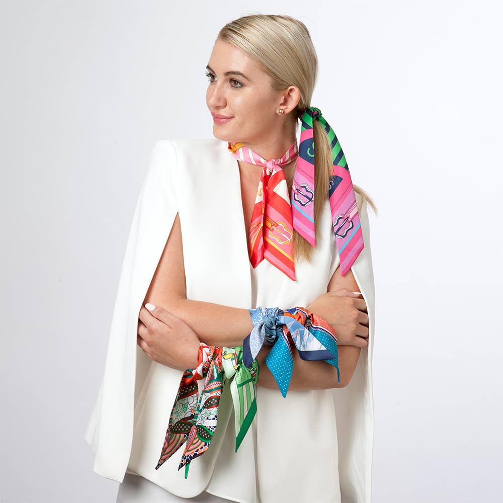 Botanical Mini Twilly Scarf Scarf by Fornash multicolor print featured on left wrist amongst other designs not for sale displayed on model with arms crossed looking right and how to wear twilly scarves in hair, around neck, on wrists