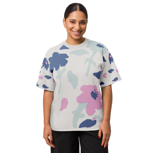 Front of Woman wearing a off-white floral-patterned sweater with blue, lilac flowers