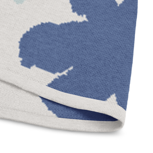 Close-up of bottom trim of fabric with blue flower pattern on off-white knitted tee