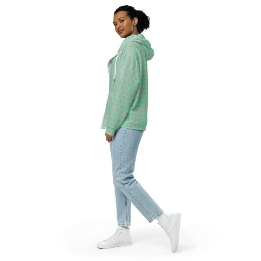 Left side of Woman wearing a green hoodie with pink bow pattern and light blue jeans 