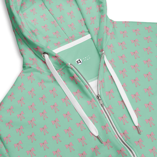 Zoomed in view of front collar, zipper, and drawstrings on Green hoodie with pink bow pattern and white zipper partially zipped