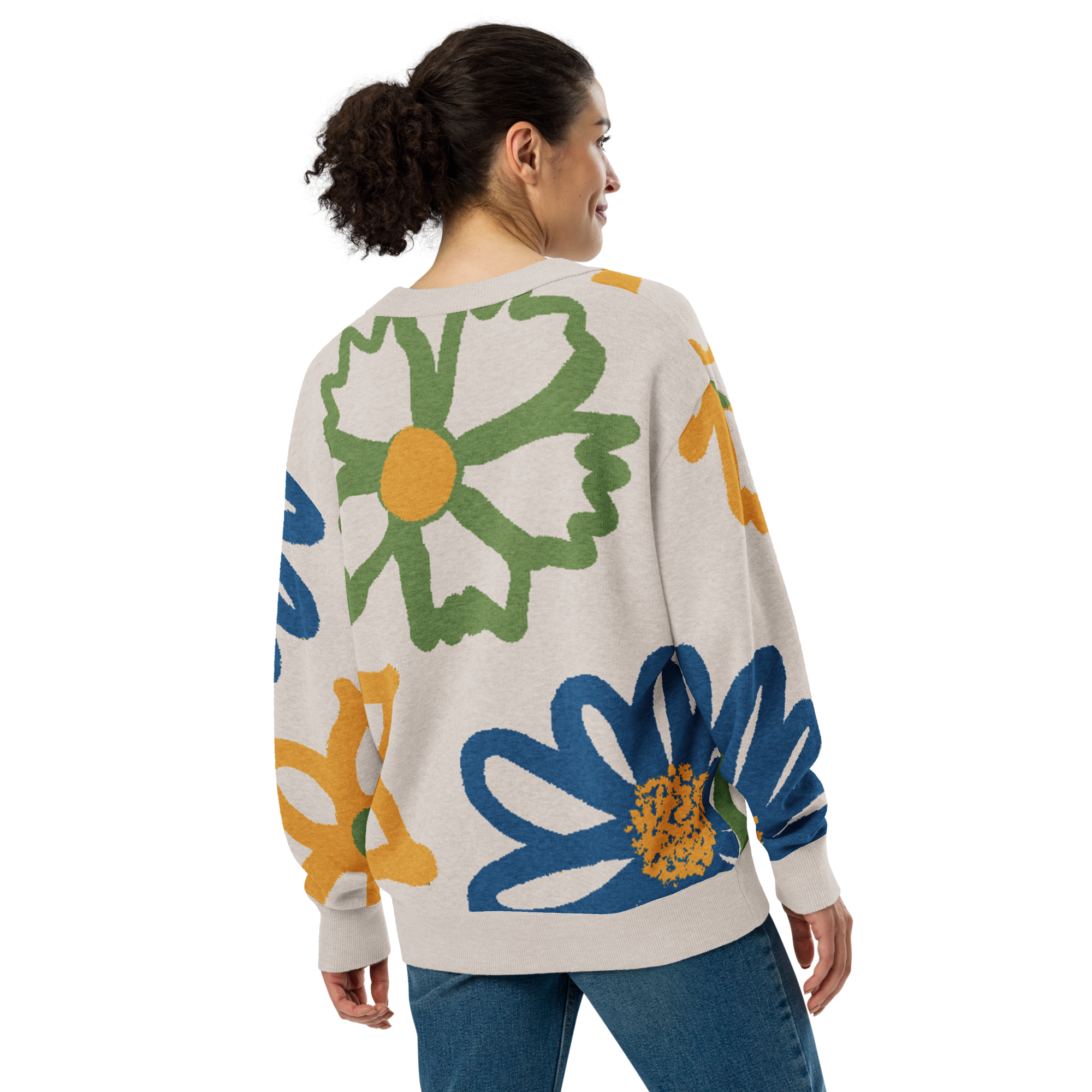 Back of Woman wearing a off-white cardigan with colorful floral designs, wearing blue jeans