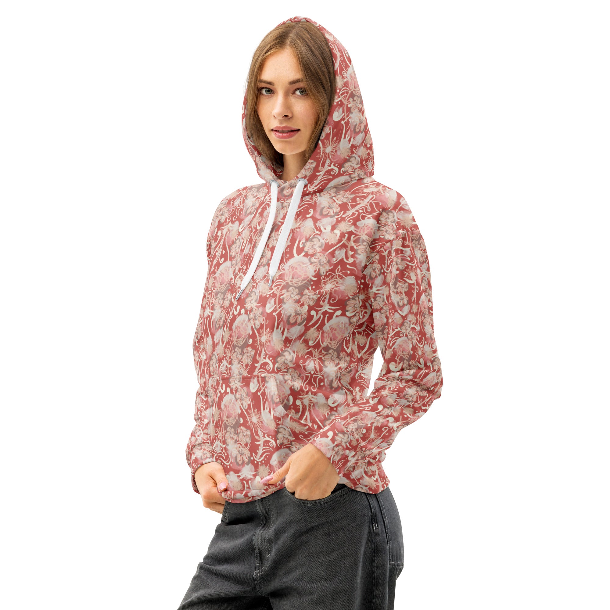 Front left of woman wearing a watermelon pink-colored, floral hoodie with pocket