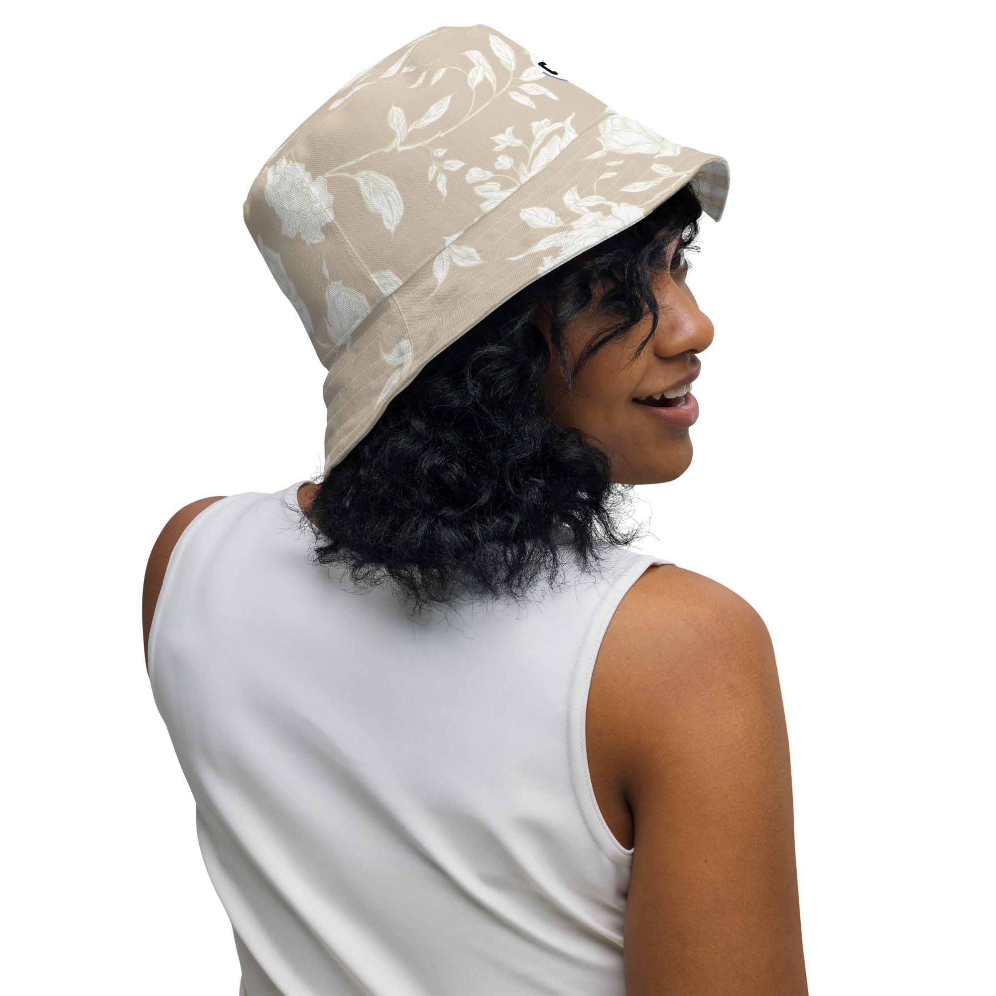 Inside Right view of Woman wearing a tan bucket hat with floral patterns looking right smiling