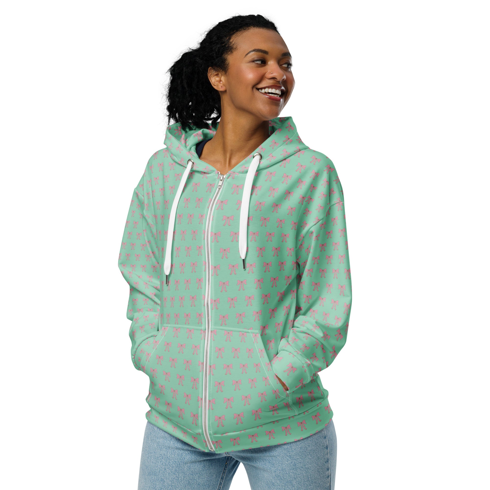 Front of Woman wearing a light green hoodie with pink bow patterns 