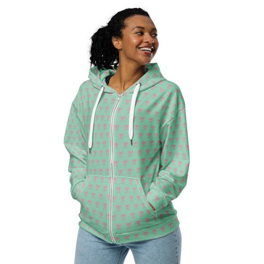 Front of Woman wearing a light green hoodie with pink bow patterns 