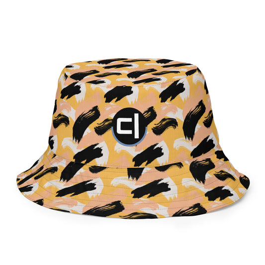 Bucket hat with black abstract pattern of paint strokes that resemble cheetah color combination with logo on front