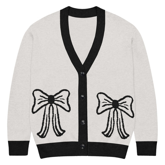 Cream cardigan with black trim and bow designs on front of item along with buttoned up closure on front 