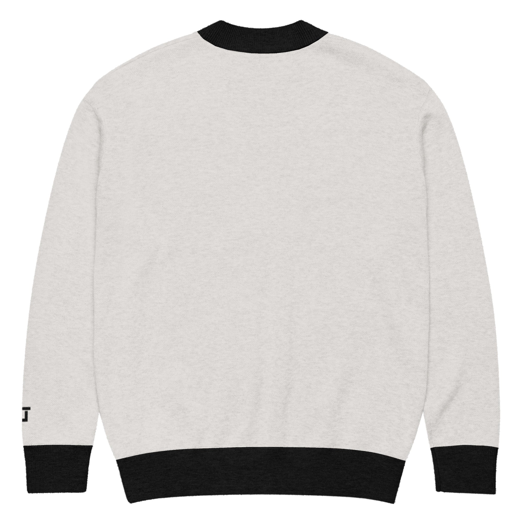 Back of Cream cardigan with black trim with branded logo "CL" near left wrist in black