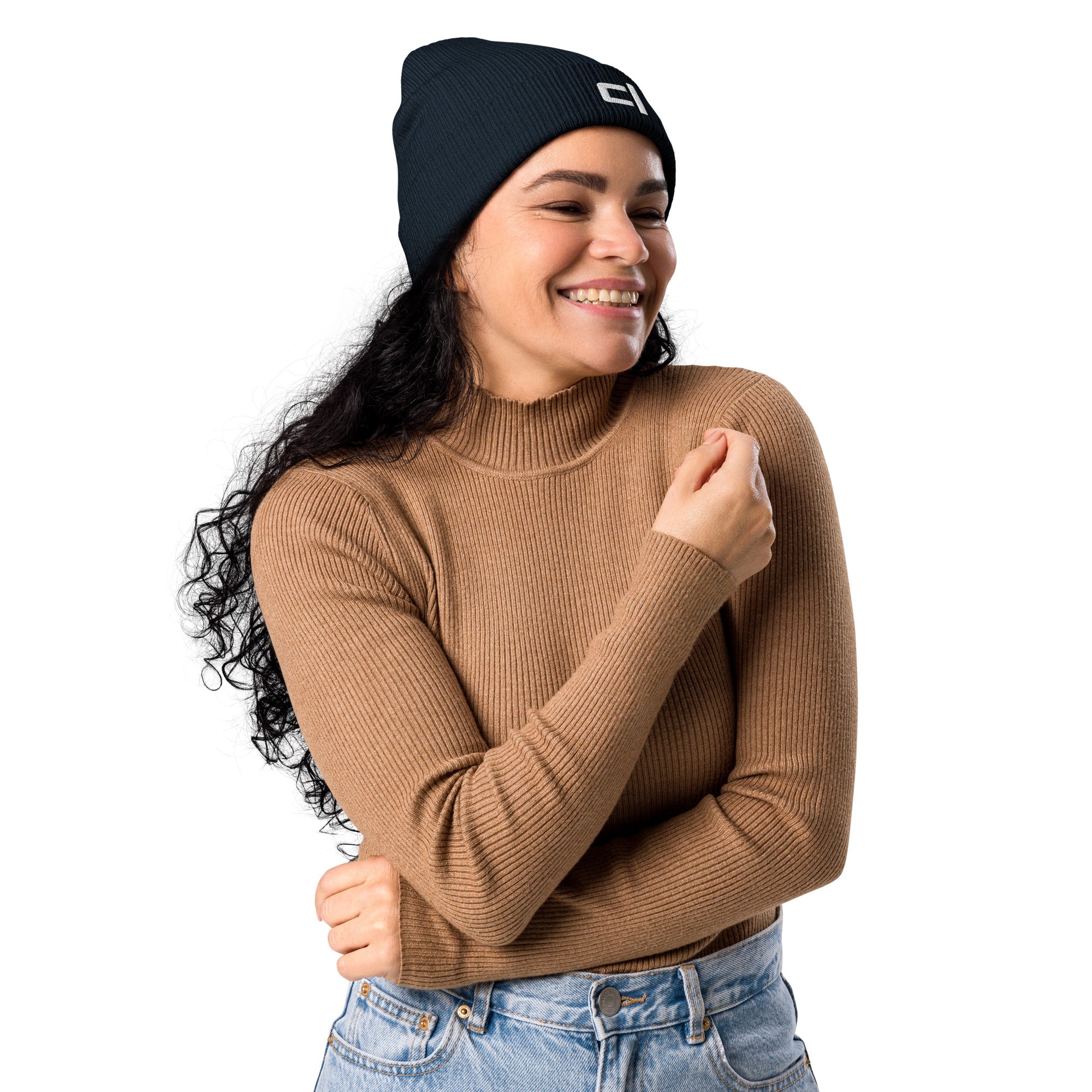 C&L Signature Organic Ribbed Beanie Beanie by Carl & Lyn deep navy front right view with embroidered Carl & Lyn logo in white and person wearing long sleeve top and jeans with arms crossed smiling