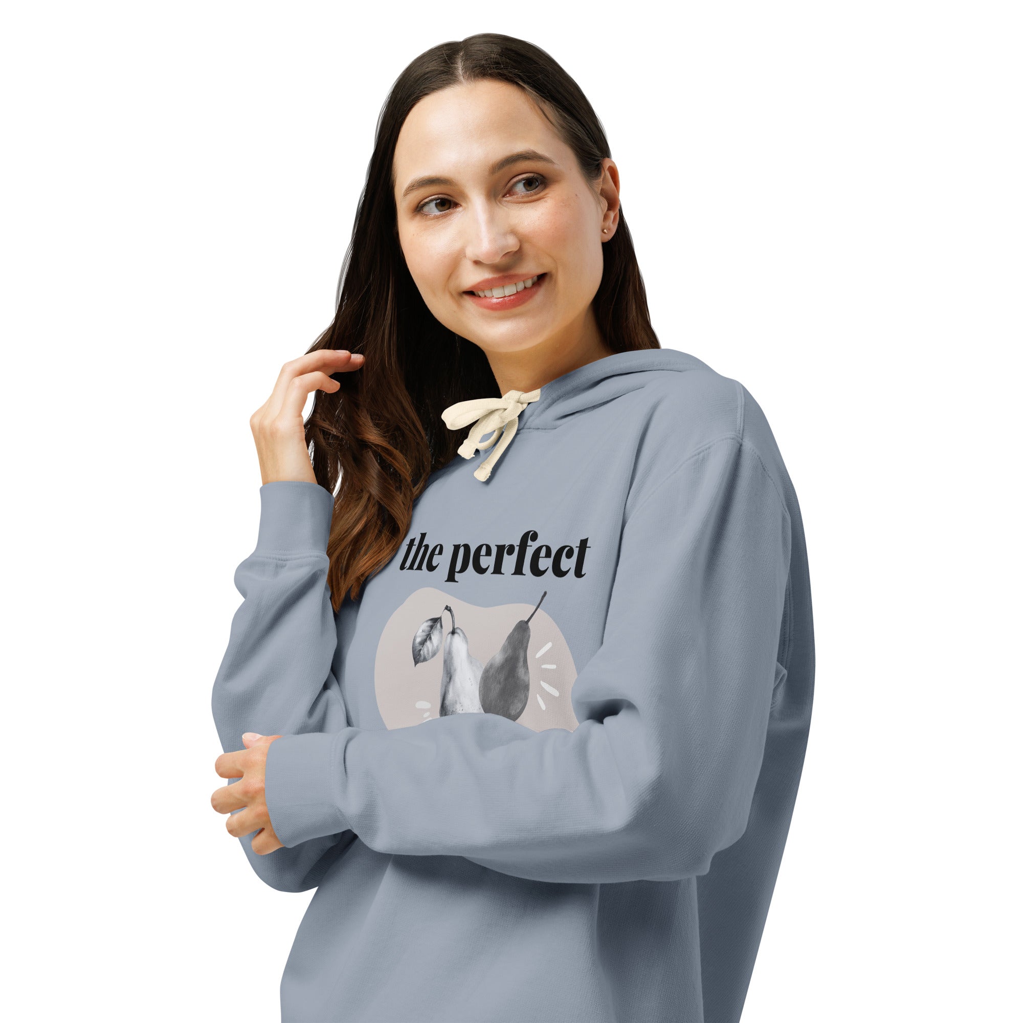 Front left of Woman wearing a denim blue hoodie with a graphic design, arms folded and looking left smiling